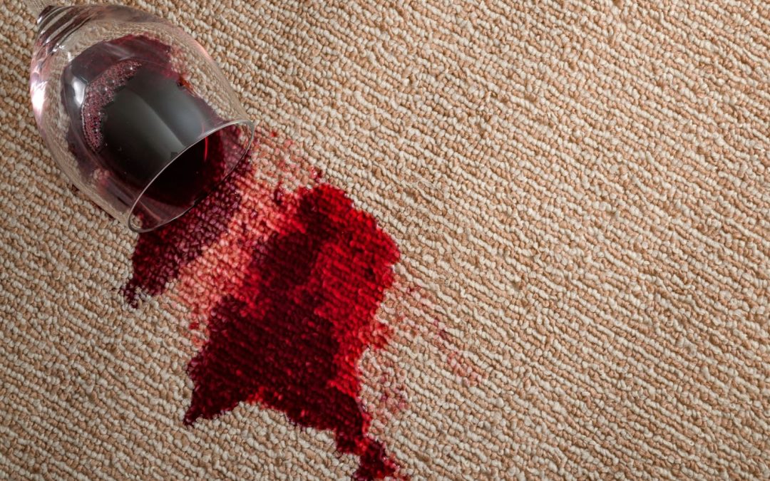 Red wine spilled on carpet, creating a stain. Image relates to carpet stains, removing stains from carpet, cleaning carpets.