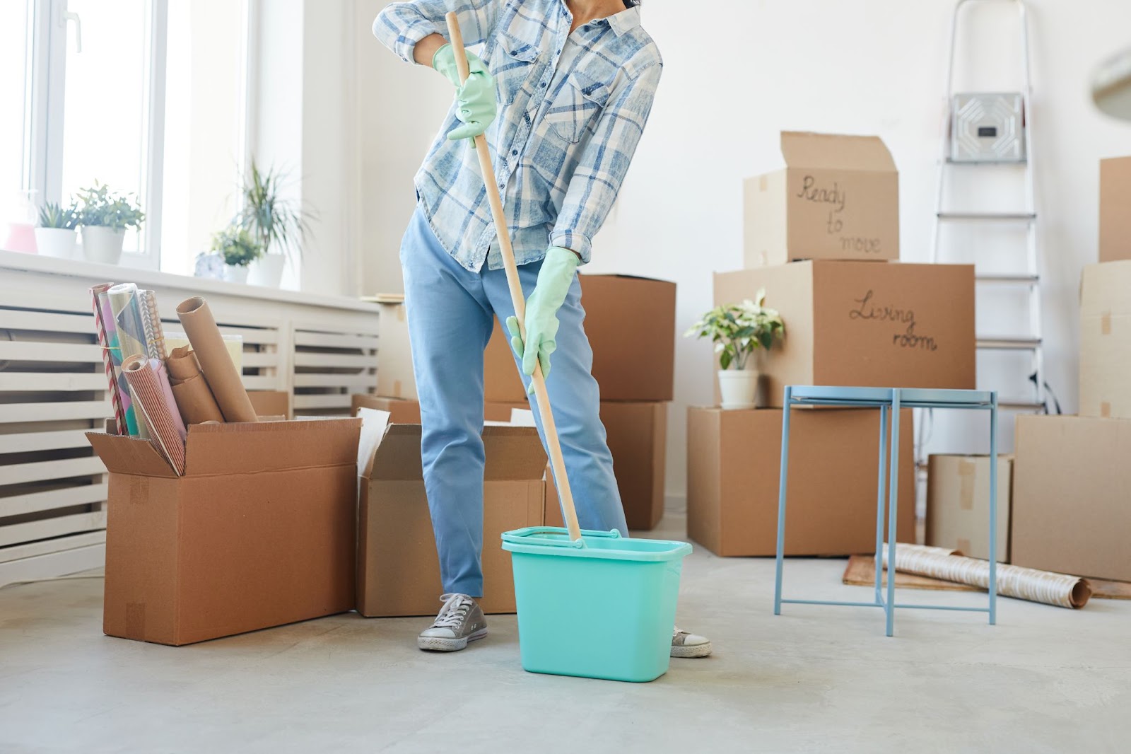 a girl wearing gloves and a mop inside a room full of box
